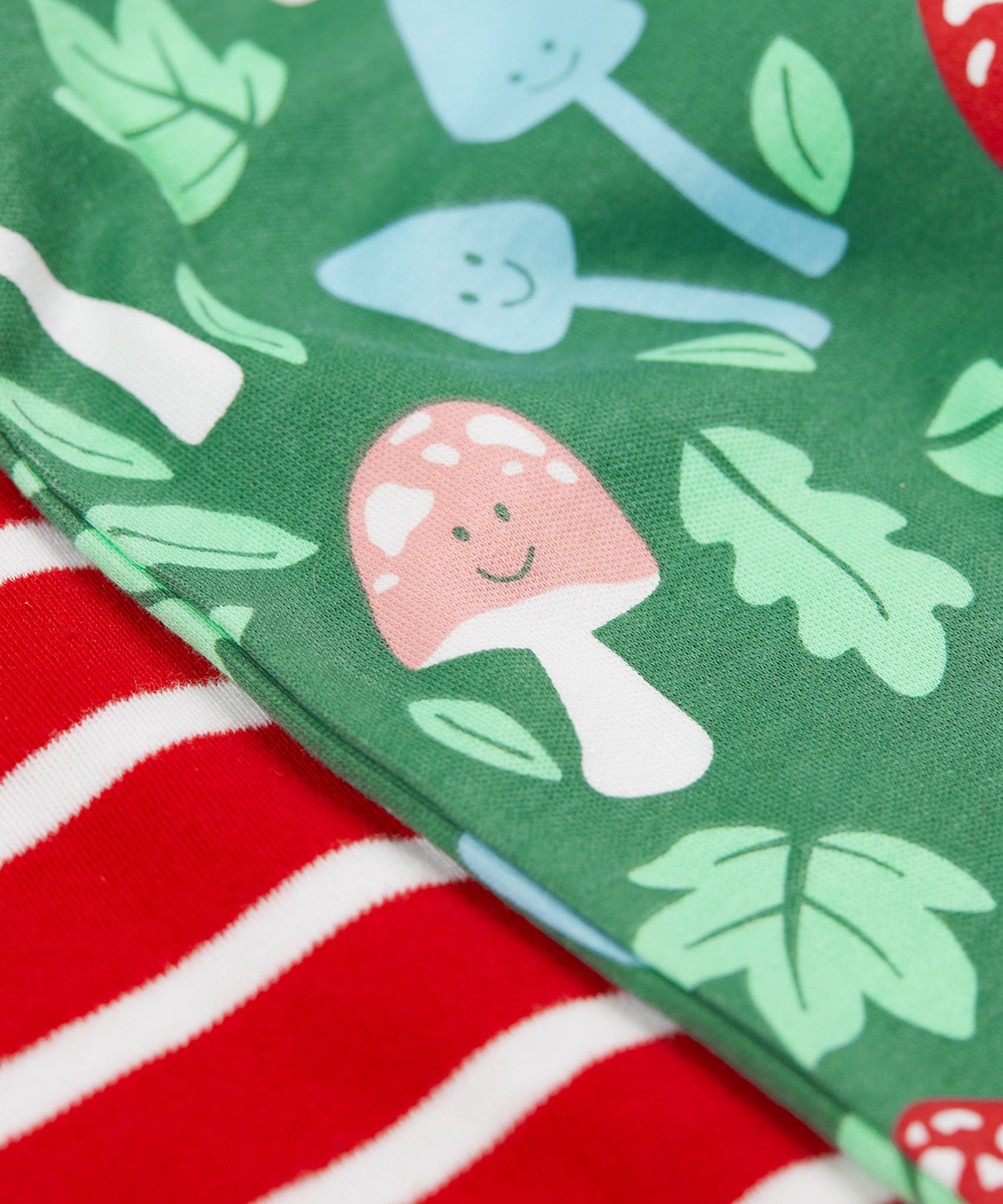 A super  close up view of the set of two Frugi organic cotton super special long sleeved organic cotton baby vests. The organic cotton vest has one striped vest and one fun guys design vest. 