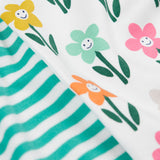 A super close up view of a set of two Frugi super special long sleeved organic cotton baby vests. One vest features the happy flowers print and the other has a turquoise and white striped design. 