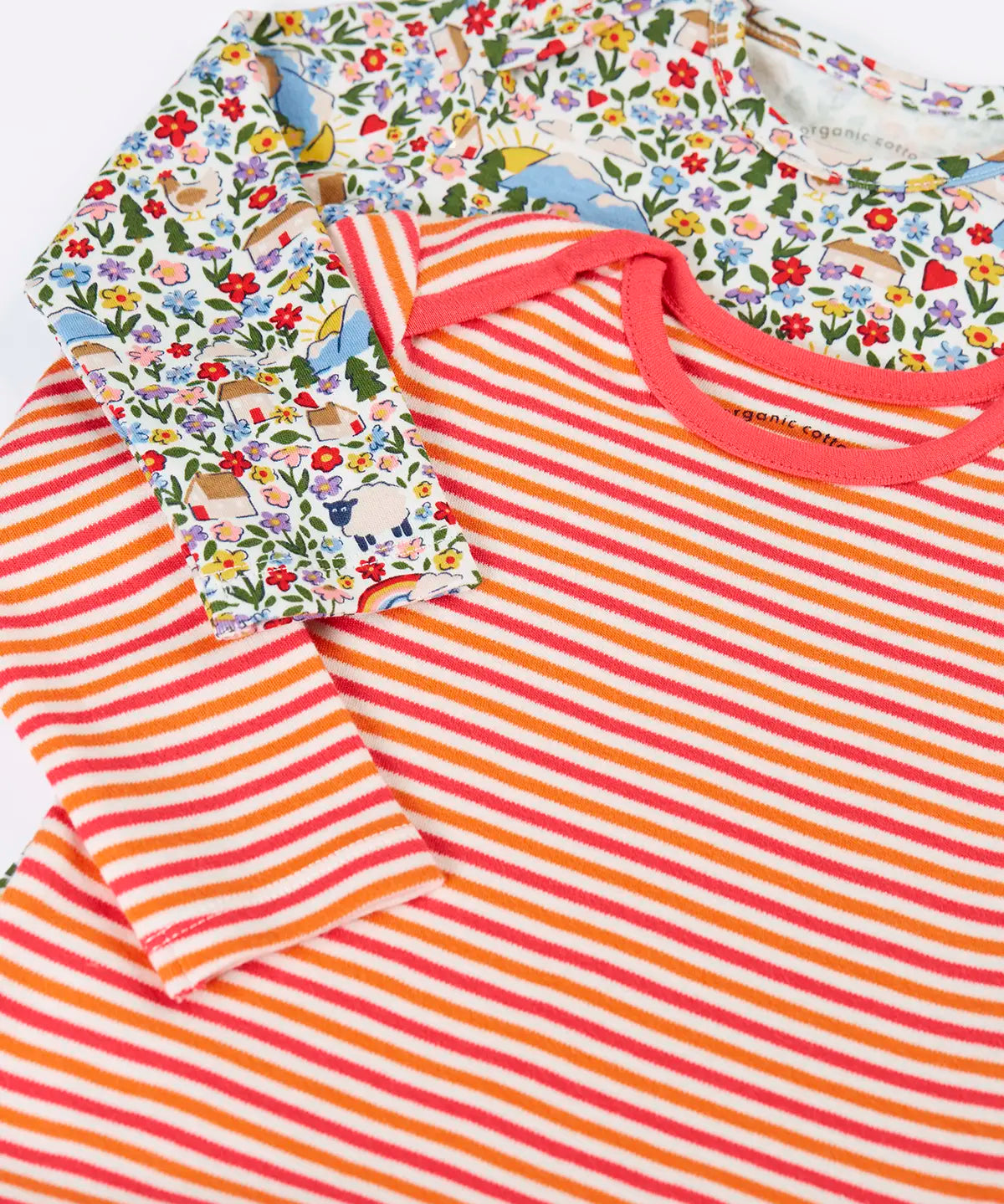 Close up of the front of the Frugi super special 2 Pack long sleeved organic cotton baby body. One has a pink, orange and white stripe, the other had an all over highland fields print.  