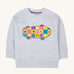 A Frugi Superb Stitched Skateboard sweatshirt. The front of the grey coloured child's jumper has an embroidered skateboard with checkerboard design.