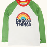 Frugi tamar raglan long sleeve top in soft white with green sleeves and a rainbow do good things graphic design on the front.