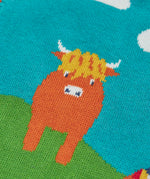 Close up of the highland coo cow on the Frugi Tavi knitted tank top with a highland scenes design.