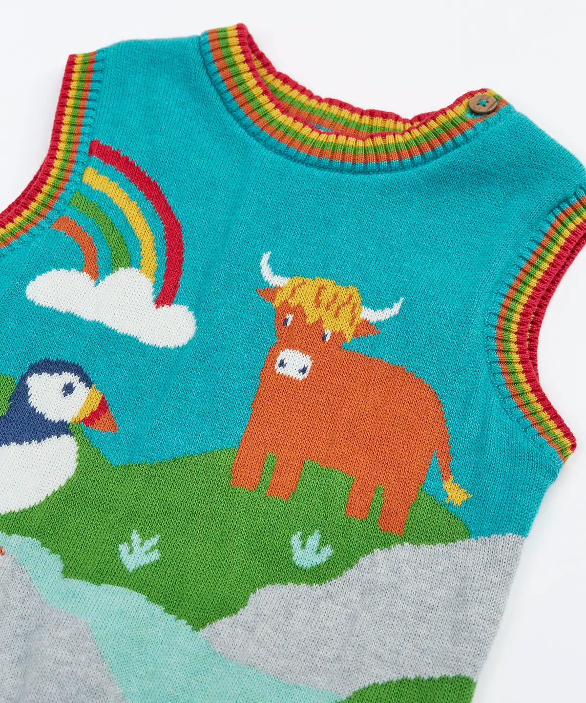 Close up of the rainbow stripes neckline and arm holes on the Frugi Tavi knitted tank top with a highland scenes design.