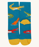 A close up of the Frugi teal multicoloured crocodile sock a soft GOTS cotton sock features a yellow sole and toes panel