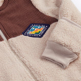 A close up of the Frugi kids ted cord snuggle suit showing the brown cord and diamond shape patch detail.