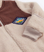 A close up of the Frugi kids ted cord snuggle suit showing the brown cord and diamond shape patch detail.