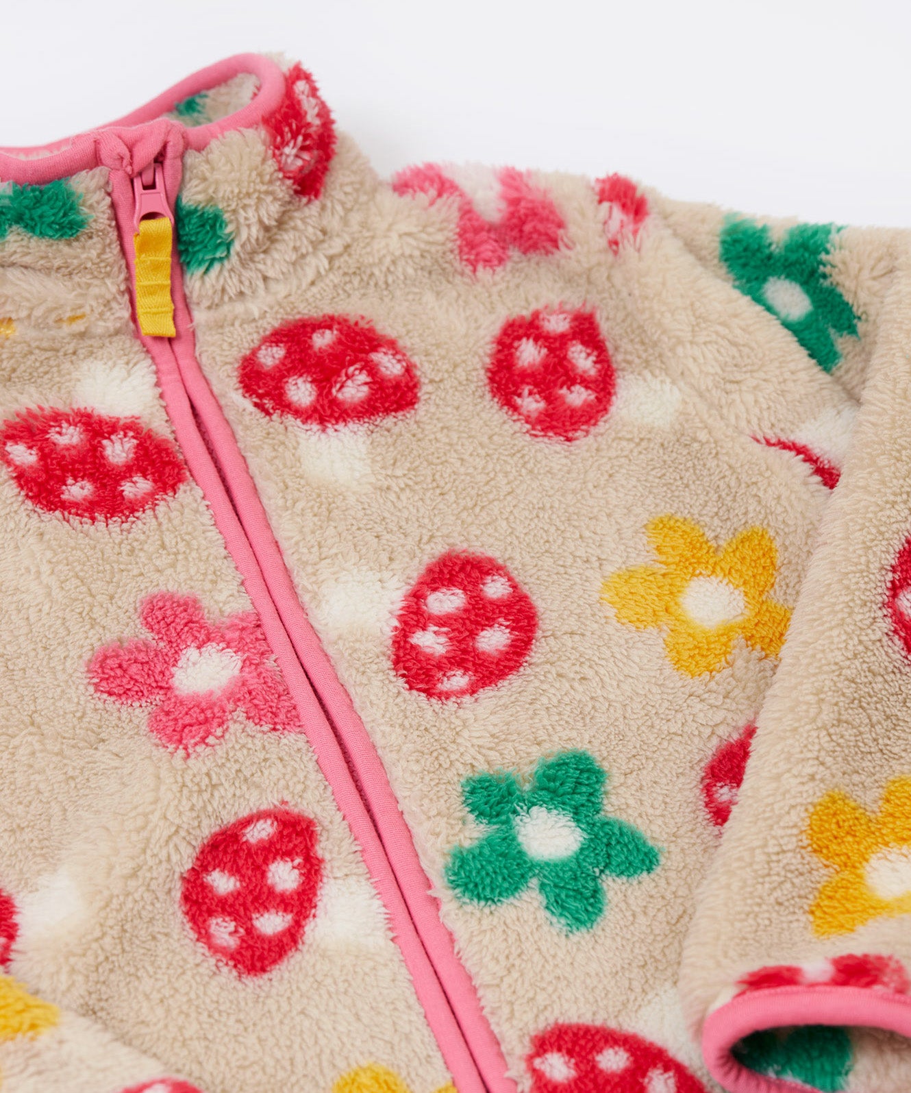A close up of the Frugi mushroom field ted stripe fleece showing the pink trim and turn up collar