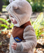 A photo showing the side profile of a child wearing the Frugi cord ted snuggle suit. 
