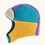 A fleece aviator-style frugi winter hat in a color-blocked pattern of teal, mustard yellow, purple, and cream.