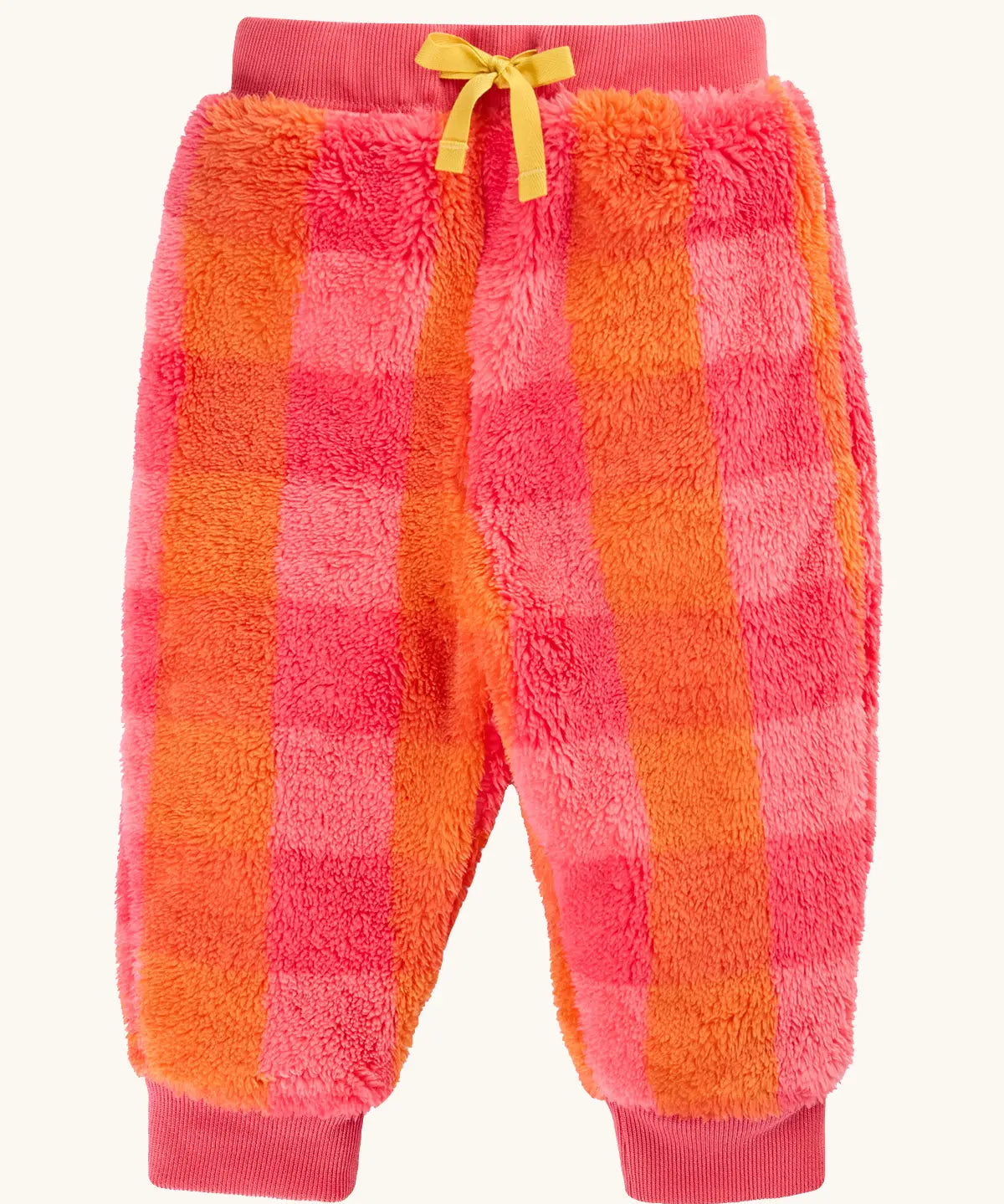 A pair of frugi fuzzy, plush jogger-style pants in a pink and orange plaid pattern, featuring a yellow drawstring bow at the waist and ribbed cuffs at the ankles.