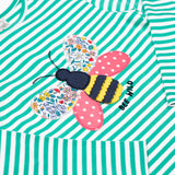 A close up of the bee applique on the front of the Frugi Theresa top with dragon green coloured stripe and bee design.