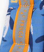 A close up of the shoulder strap on the Frugi kids trail blazing backpack in penguin waddle. Showing the reflective strip running down the strap