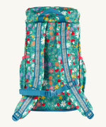 The back of the Frugi kids trail blazing backpack in wild woods showing the shoulder strap detail with blue trim. Features a handy loop for easy carrying and chest buckle for a secure fit
