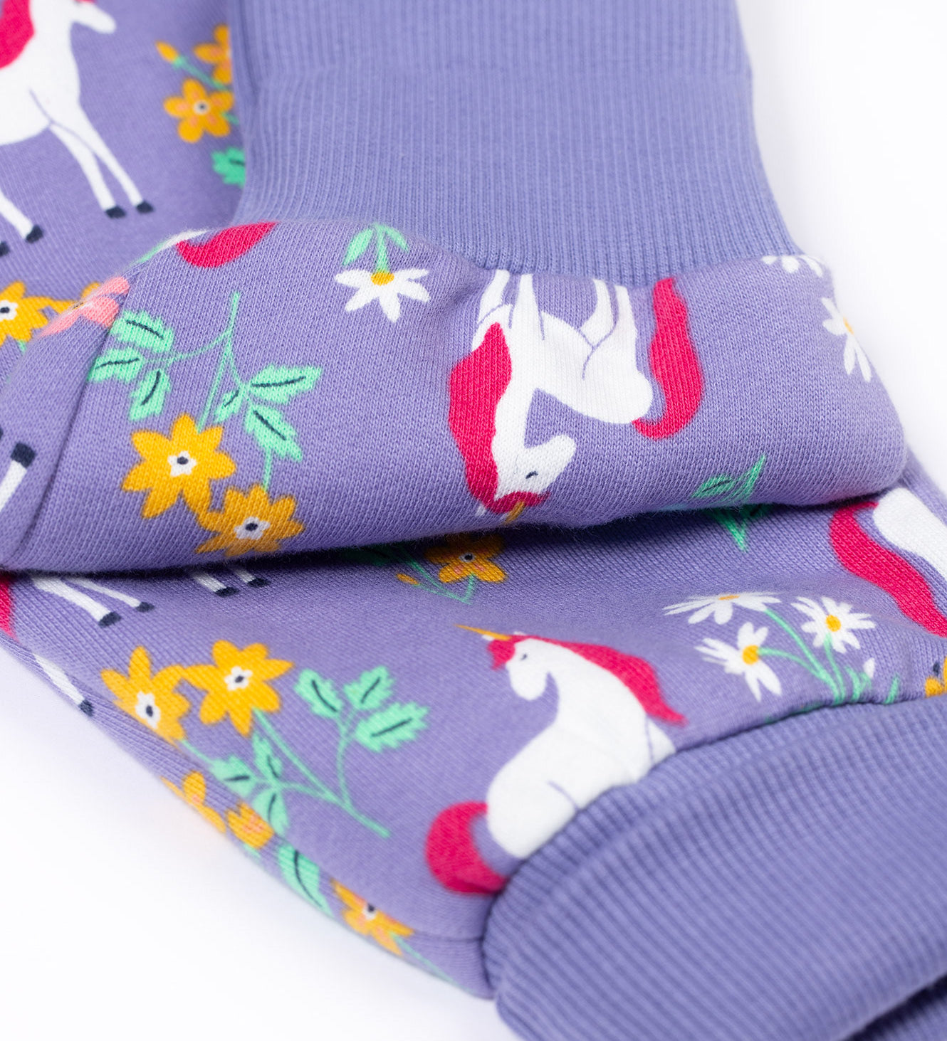 A close up of the fold-able cuffs on the Frugi Organic Cotton purple unicorn floral print Children's Big Snuggle Suit. This all in one snuggle suit is a part of a wide range of organic cotton clothing for children available here at Babipur. 