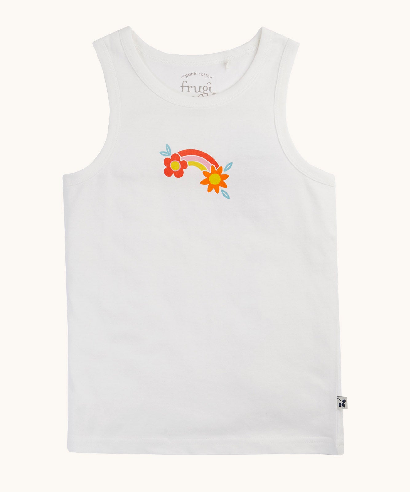 The white vest with rainbow flower graphic from the Frugi varlie bloom vest 2 pack multipack. The sleeveless children's vest has a graphic in the middle of the chest featuring an orange pink and yellow rainbow with  a flower each end of the rainbow on a crisp white background.