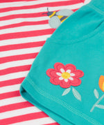 A close up of Frugi kids bee watermelon stripe outfit showing the bee and  flowers applique on a light blue, pink and white organic cotton fabric