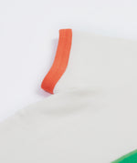 Close up of the Frugi kids let's create white t-shirt showing the orange trim on the sleeve on white organic cotton fabric