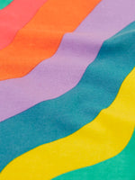 Close up of the Frugi ric rac rainbow organic cotton material on the wide leg children's trousers. 