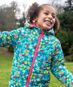 A child wearing the Frugi toasty trail reversible jacket showing the playful woodland inspired design with pink zip detail on post consumer recycled polyester fabric