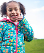 A child wearing the Frugi toasty trail reversible jacket showing the playful woodland inspired design with pink zip detail and light blue trim on the arm on post consumer recycled polyester fabric