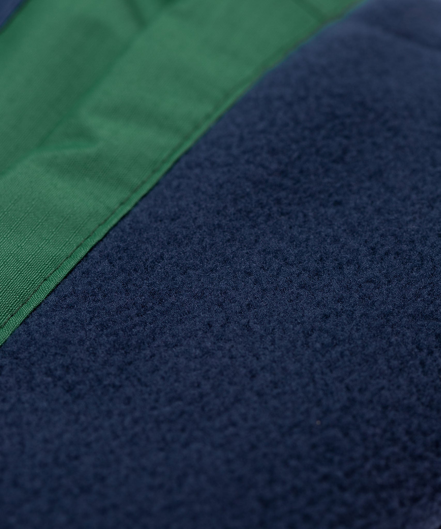A close up of the navy fleece lining on the Frugi Wilderness green trousers with navy blue coloured knee patches.