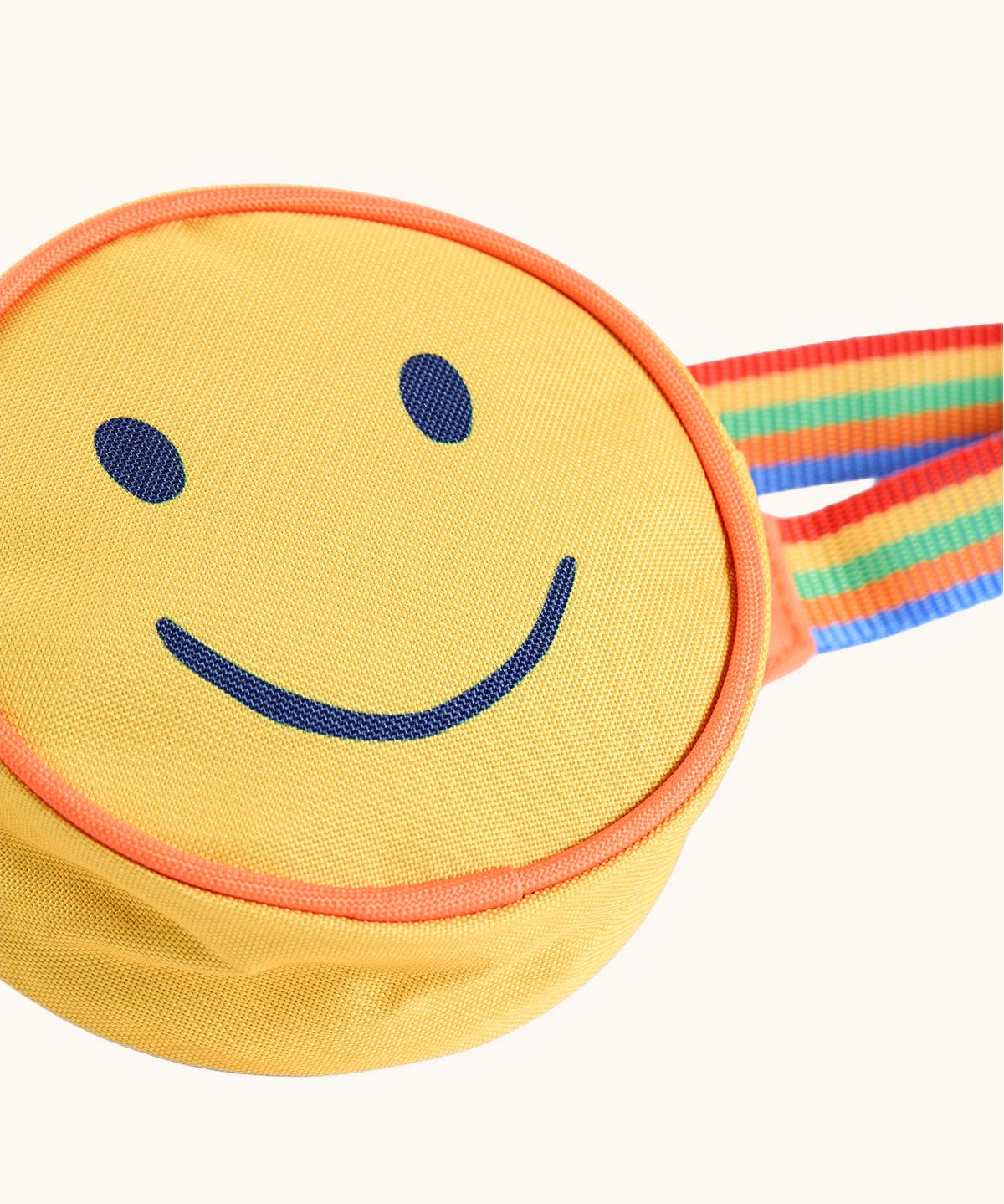 A close up of the front of the Frugi yellow happy smiley face children's rainbow coloured belt bag. 