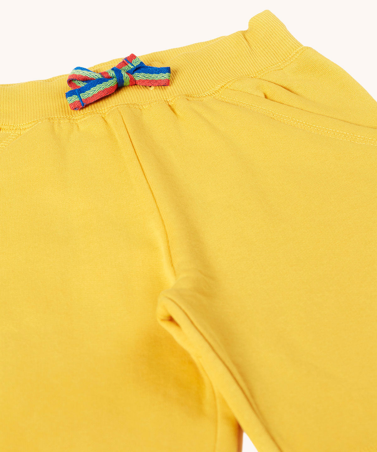 Frugi Bumblebee yellow Organic Cotton Samson Summer Shorts with rainbow stripe waist tie.