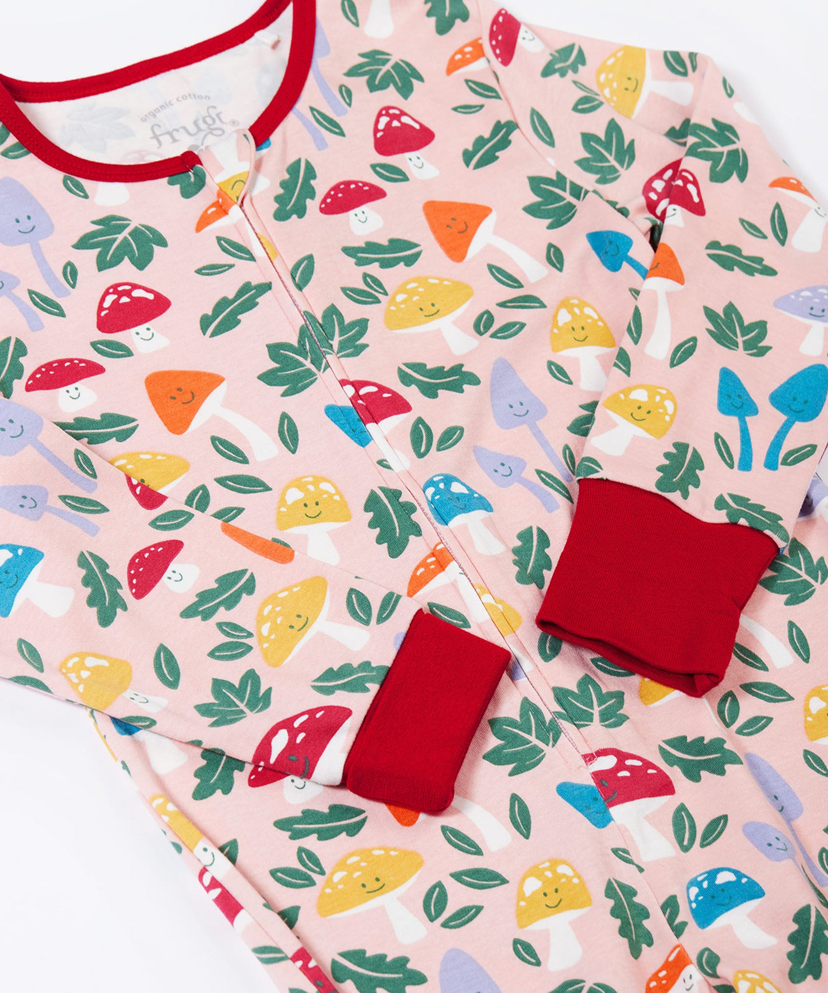 A close up of the red coloured sleeve cuffs on the Frugi fun-guys design Zelah zip up all in one. The cuffs can be  folded down for extended wear.