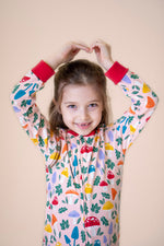 A close up of a child wearing the Frugi Zelah fun guys all in one zip suit available at Babipur showing the fund woodland print and full length zip detail