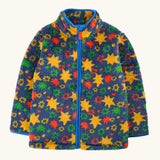 A frugi children's fleece zip-up jacket with a colorful star and floral pattern on a navy blue background, featuring a bright blue zipper and collar trim.