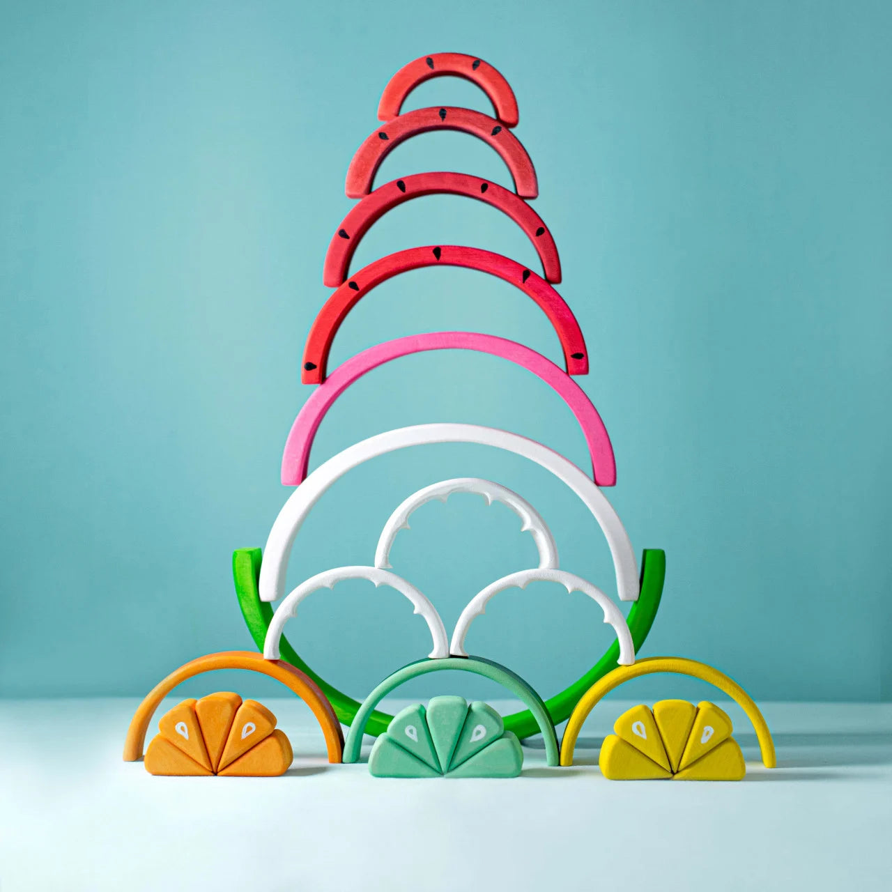 Bumbu Toys wooden stacking Watermelon toy stacked alongside citrus stacking toys from the same fruit collection, showcasing the range of colourful wooden fruit toys from Bumbu.
