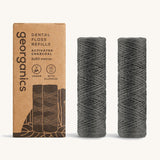 Georganics activated charcoal fluoride dental floss refill tubes, next to cardboard packaging.