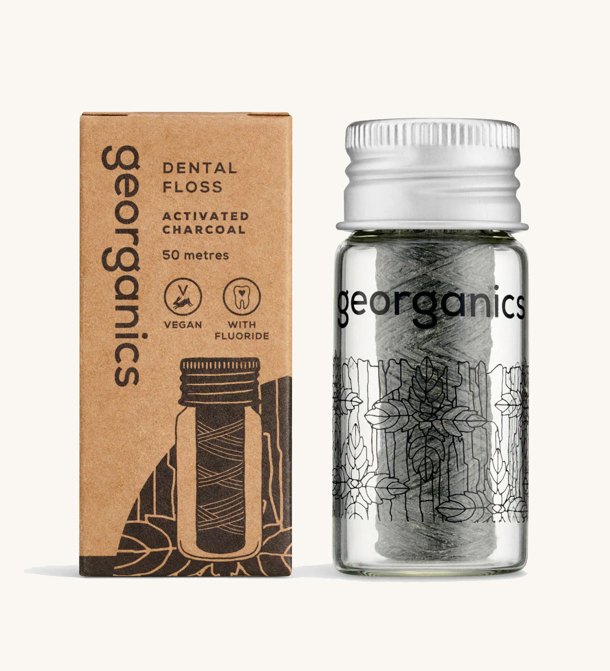 Georganics Charcoal Dental Floss with fluoride in a glass jar, next to cardboard packaging. 