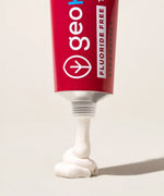 Tube of Georganics fluoride free strawberry hydroxyapatite toothpaste showing contents coming out of the nozzle