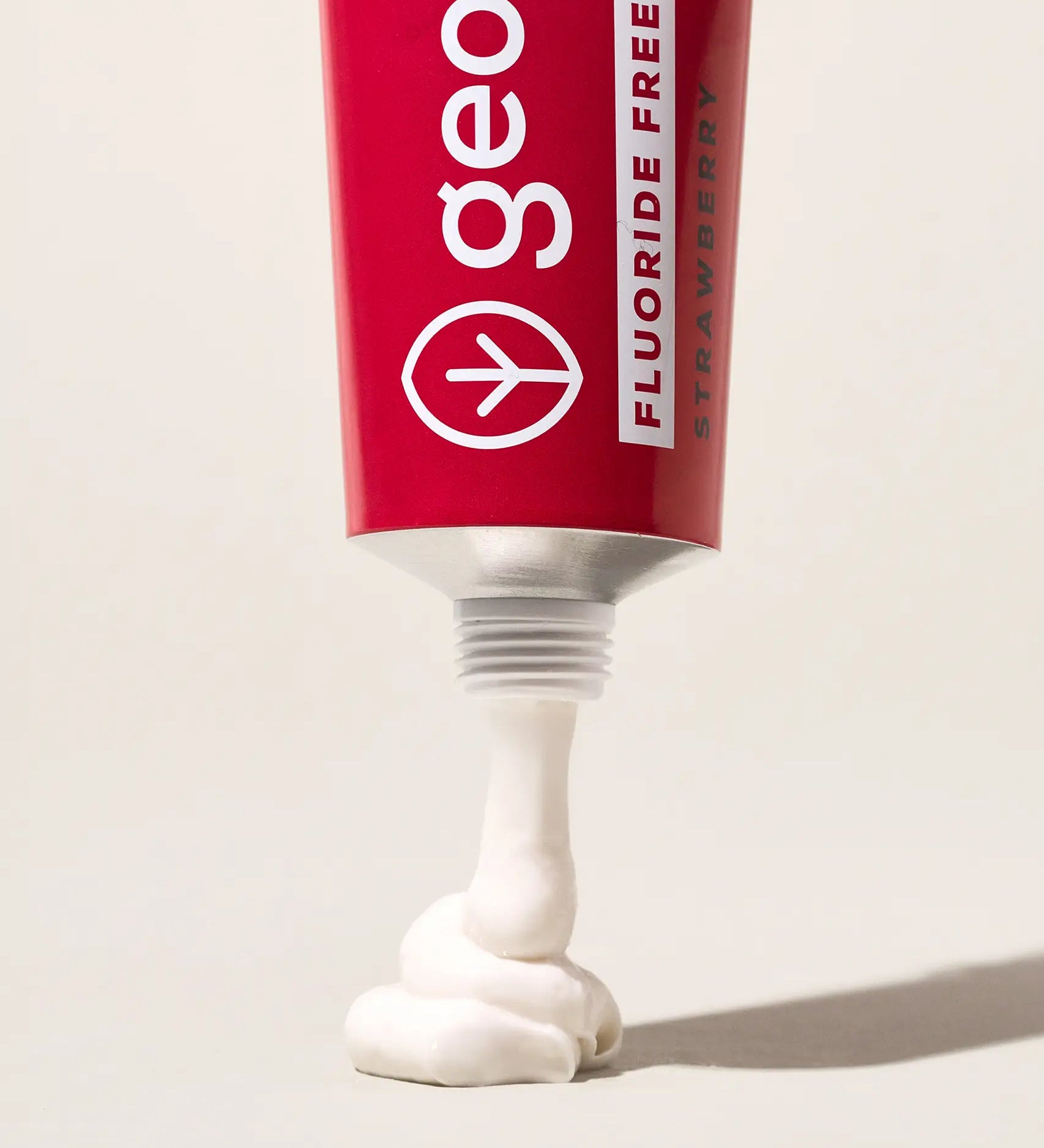 Tube of Georganics fluoride free strawberry hydroxyapatite toothpaste showing contents coming out of the nozzle