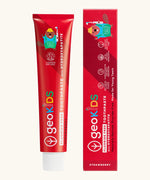 Front of the Georganics strawberry hydroxyapatite fluoride free toothpaste tube next to matching branded packaging 