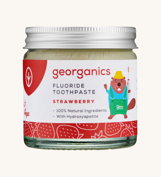 A jar of the kids strawberry fluoride toothpaste with a picture of a beaver on the jar on a cream background