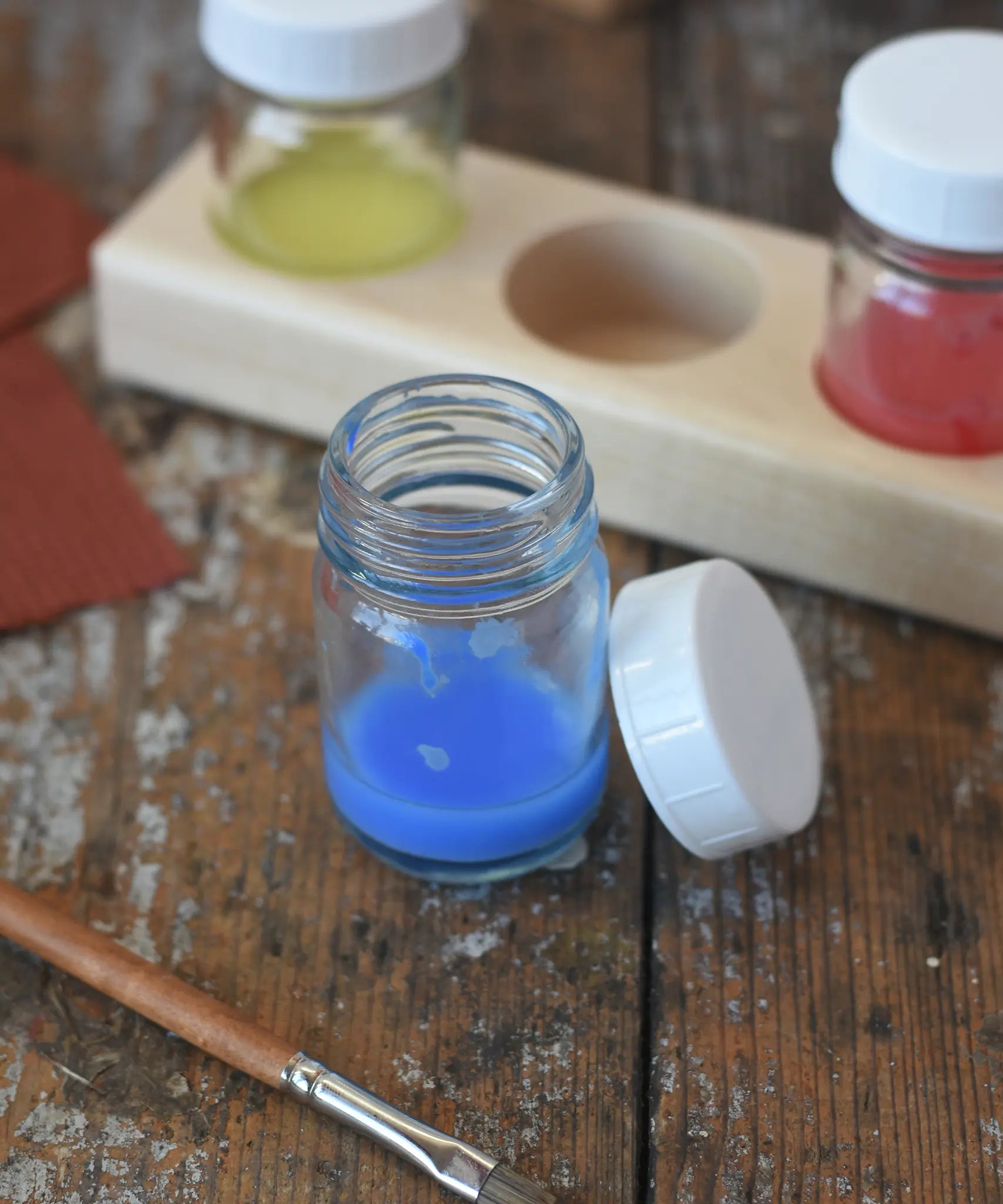 50ml Glass paint jar pot with some blue paint inside. 