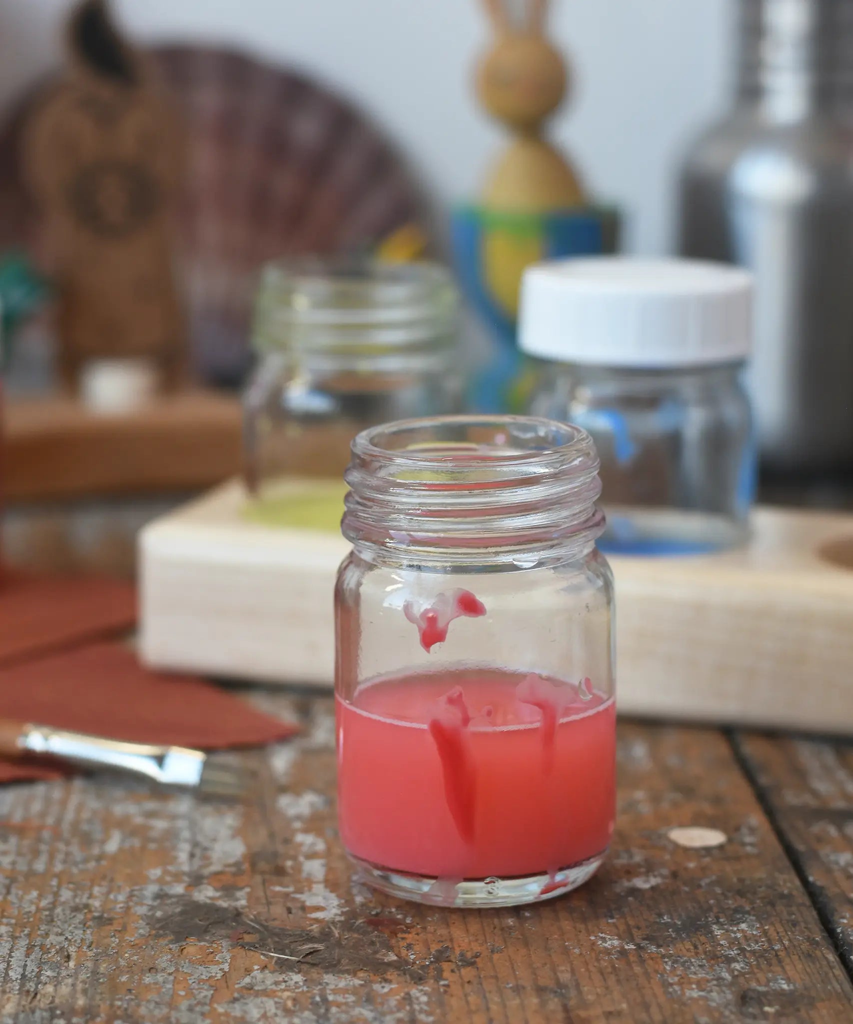50ml Glass paint jar pot with red paint inside.
