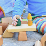 Two blocks from the Glückskäfer 17 Large Natural Blocks set used to create a pretend seesaw for wooden peg dolls. 