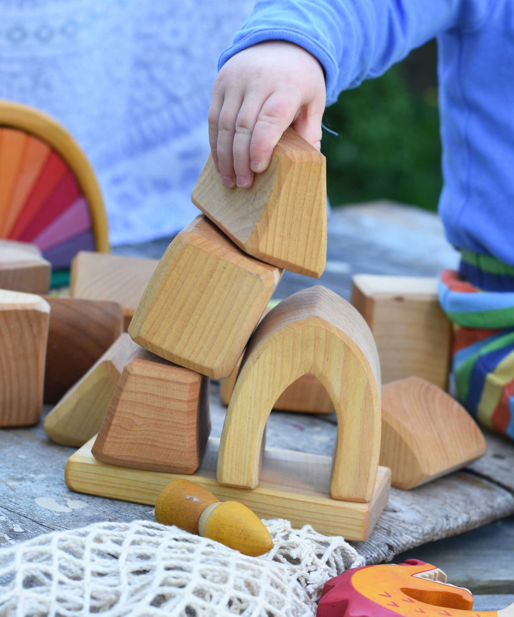 A child playing with the blocks from the Glückskäfer 17 Large Natural Blocks set. 
