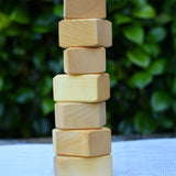 7 blocks from the Glückskäfer 17 small natural blocks set stacked up on their side. 