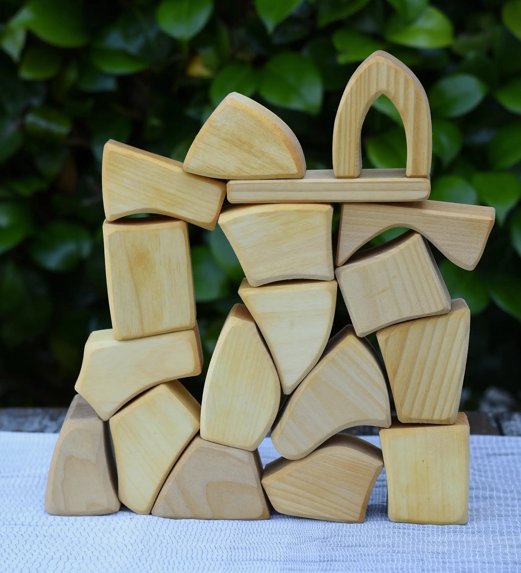 Glückskäfer 17 small natural blocks stacked up on a table outoors. 