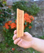 A piece of track from the Glückskäfer 23 Piece Wooden Marble Track held up in an adult's hand.
