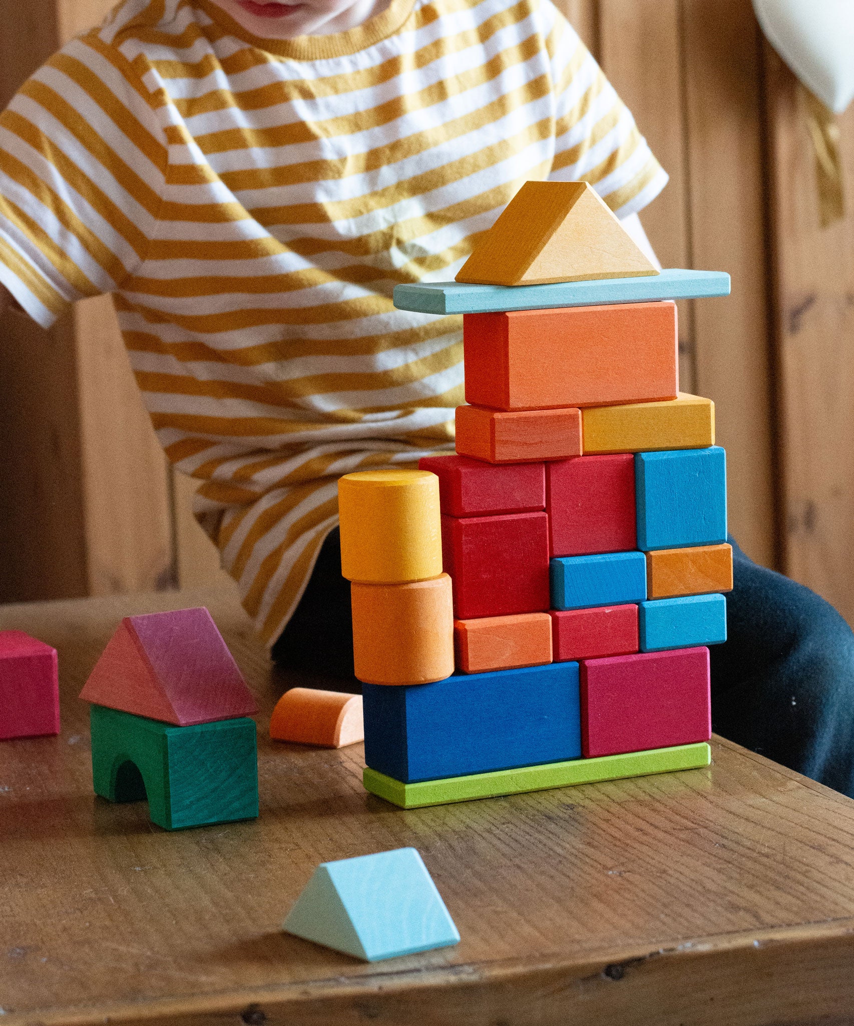 A child playing with the Glückskäfer 27 Piece Building Blocks Set.