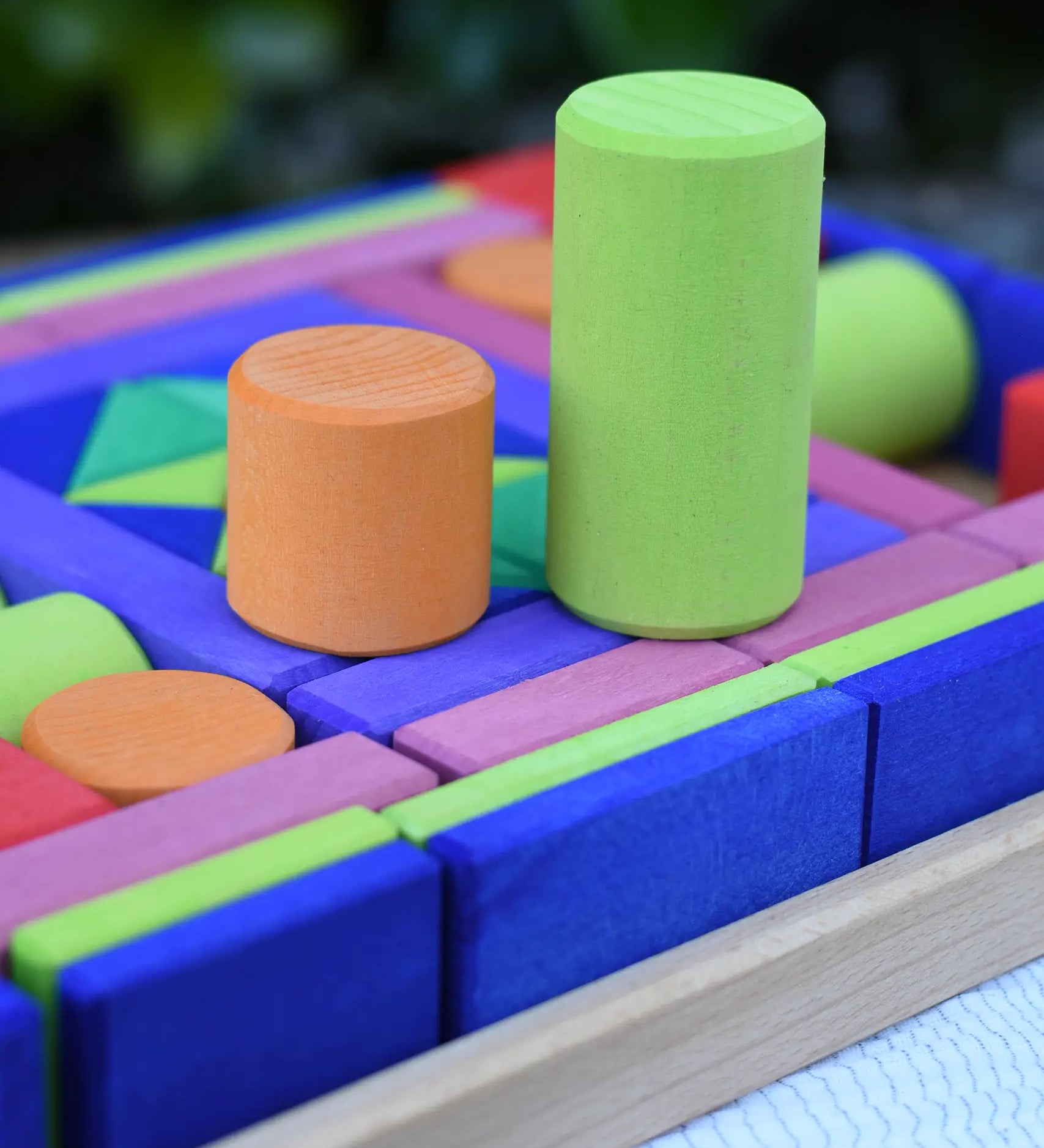 Glückskäfer 53 piece big provence wooden blocks set in a storage display tray with two cylinder blocks taken out and placed on top.