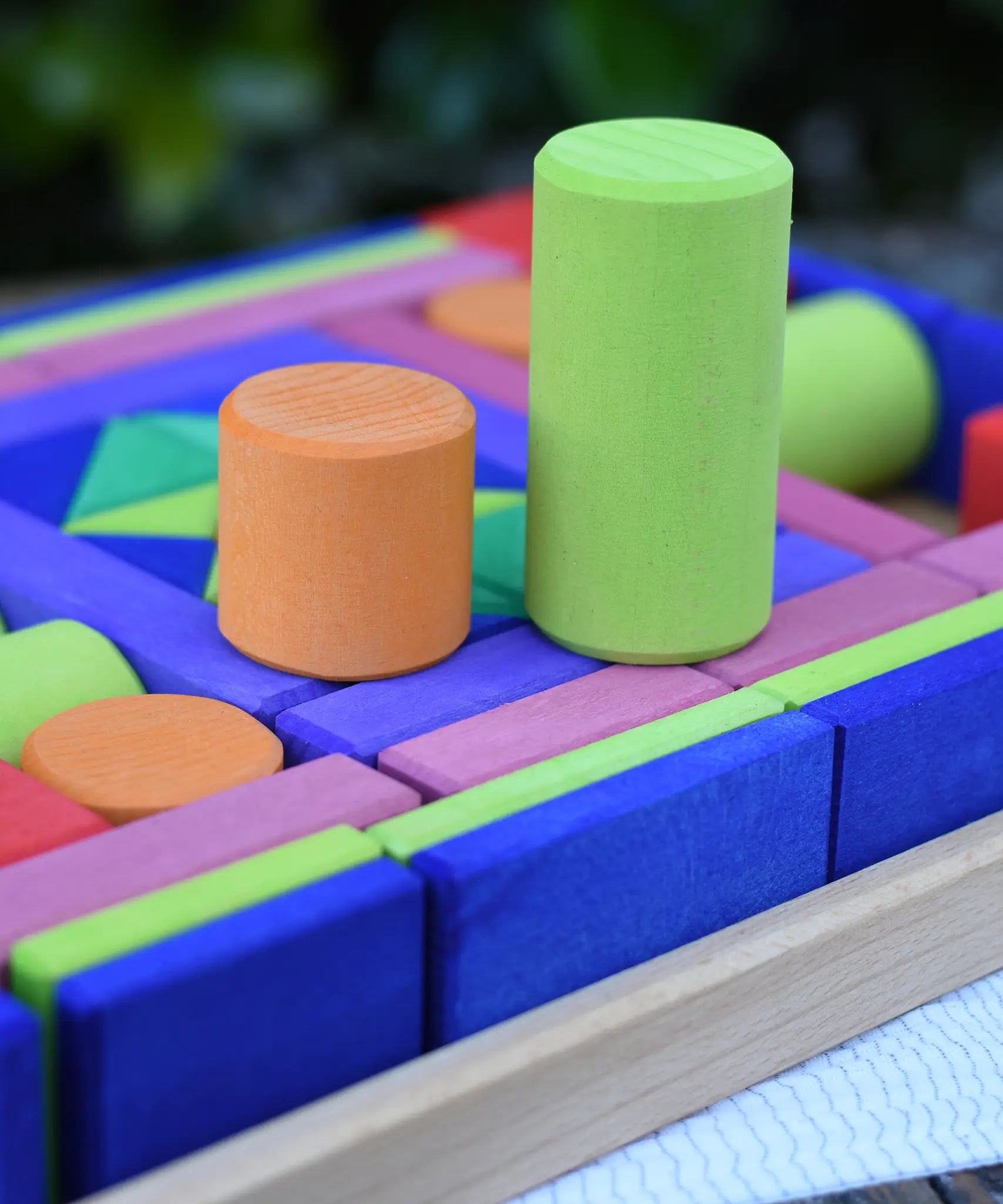 Glückskäfer 53 piece big provence wooden blocks set in a storage display tray with two cylinder blocks taken out and placed on top.