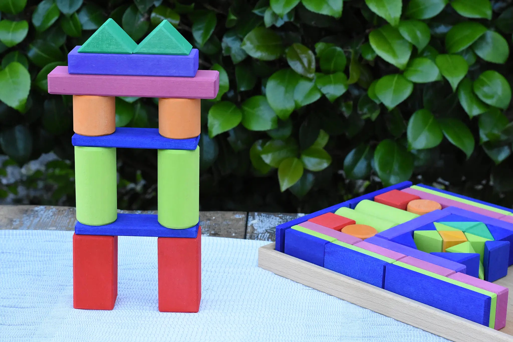 Glückskäfer 53 piece big provence wooden blocks set in a storage display tray with a tower created using some of the blocks built next to it.