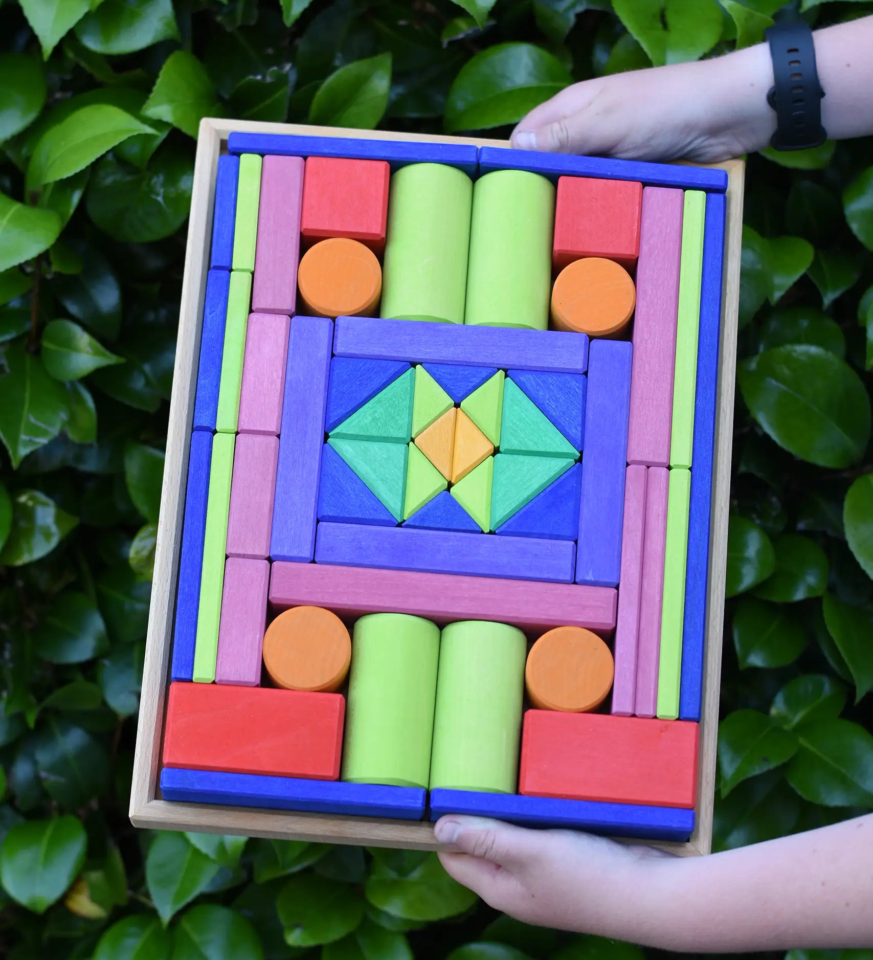 Glückskäfer 53 piece big provence wooden blocks set in a storage display tray in a child's hands.
