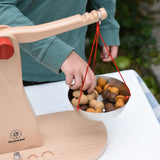 Child placing Grapat mandala pieces onto the Glückskäfer balance with weights children's weighing scales toy.  